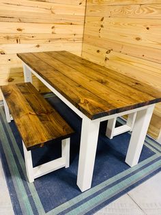 a wooden table and bench sitting on top of a rug