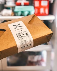 a brown paper bag with a fork and knife on it in front of some shelves