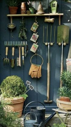 gardening tools are hanging on the wall next to potted plants and other garden implements