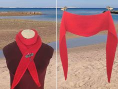 a red knitted scarf on a mannequin at the beach