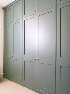 an empty room with green cabinets and white walls