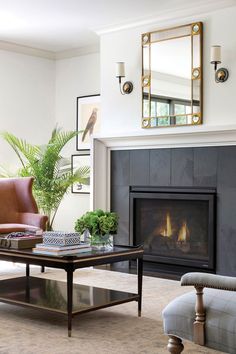 a living room filled with furniture and a fire place in front of a mirror on the wall