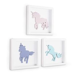 three unicorns are mounted on the wall in different colors and sizes, one is pink, one is blue