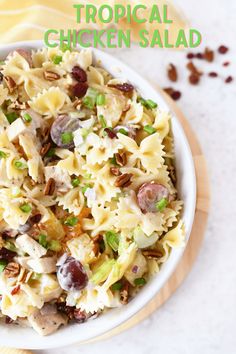 a white bowl filled with pasta salad on top of a wooden cutting board