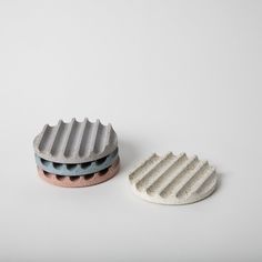 two ceramic objects sitting next to each other on a white surface, one has a hole in the middle