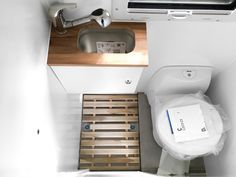 an overhead view of a small bathroom with a toilet and sink in the stall area