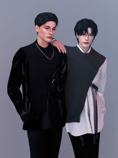 two people standing next to each other in front of a gray background and one is wearing a black sweater