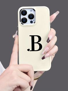 a woman holding up her phone case with the letter b on it and nail polish