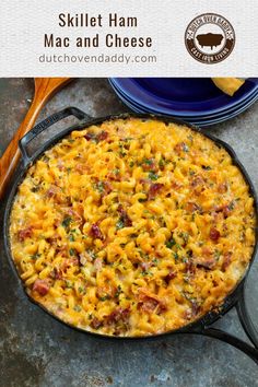 a skillet with macaroni and cheese in it next to a blue plate