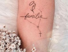 a woman's leg with a tattoo that reads, family and a cross on it