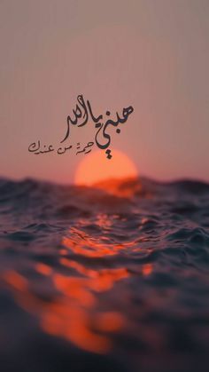 the sun is setting over the ocean with arabic writing on it's face and in the water