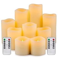 six lit candles with remote controls in front of them