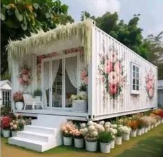 a house made out of shipping containers with flowers on it