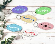 four different colored keychains with the word caprictoris on them and some plants