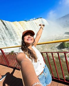 a woman is taking a selfie in front of the water fall at niagara falls