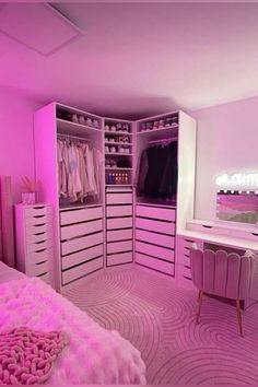 a bedroom with pink lighting and lots of closet space in the corner, including a dressing table