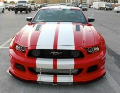 a red and white mustang parked in a parking lot