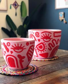 two red cups sitting on top of a wooden table