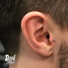 a man's ear is shown with a piercing in the middle