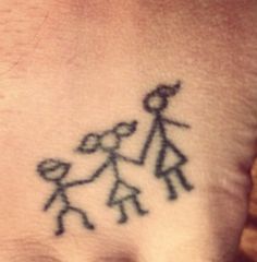 a small tattoo on the wrist of a person with an arrow and two people holding hands