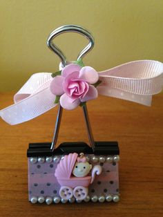 a pink flower is placed on top of a miniature baby carriage