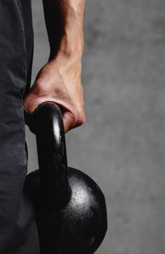 a person holding a black object in their hand and lifting it with his right arm