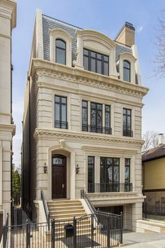 this is an image of a two story house in the city with stairs leading up to the front door