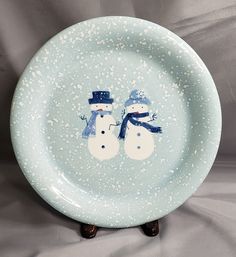 a plate with two snowmen painted on it