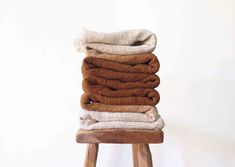 a stack of towels sitting on top of a wooden stool