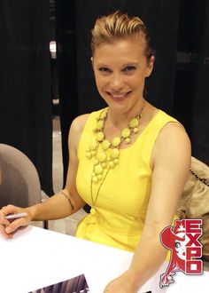 a woman in a yellow dress sitting at a table