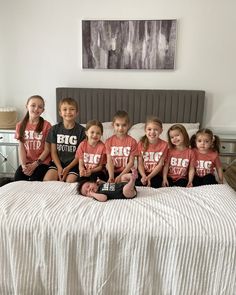 a group of young children sitting on top of a bed