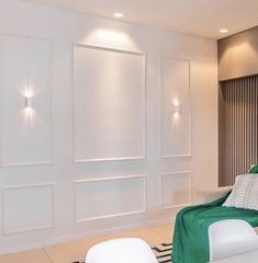 a living room with white furniture and green blankets on the couch, along with black and white striped rugs