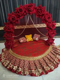 a bed made out of red roses with gold trimmings on the bottom and sides