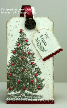 a christmas card with a tree on it and a tag hanging from the front that says tis