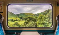 the inside of a train car looking out at mountains and trees from it's windows