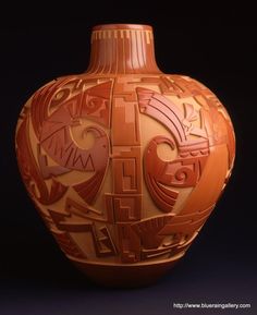 an orange vase with abstract designs on it