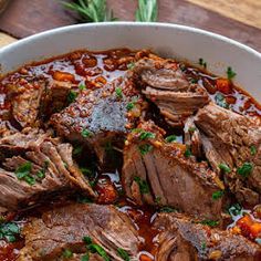 a white bowl filled with meat and vegetables