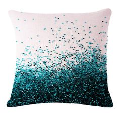 a blue and white pillow with black speckles on the front, against a white background