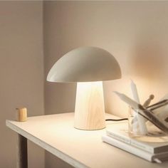 a white lamp sitting on top of a table next to a pile of books and scissors