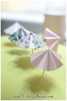 three paper umbrellas sitting on top of a table