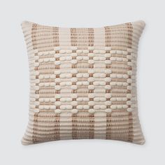 a brown and white pillow with woven squares