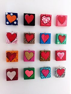 many different colored hearts are hanging on the wall