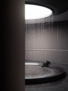 a shower head in the middle of a circular room with rain coming down on it