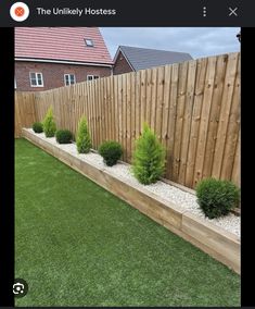 a fenced in yard with grass and bushes next to it on top of the lawn