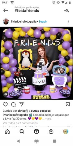 a woman standing in front of a cake on top of a table with balloons around her