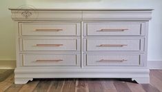 a white dresser with gold handles and drawers