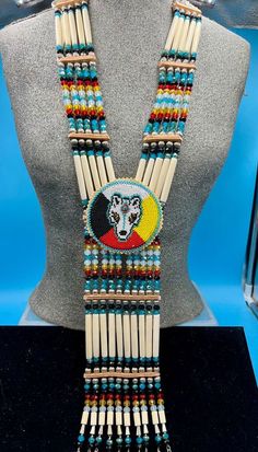 Bone hairpipes and crystal beads are often seen as part of traditional Native American dancers.  This modified breastplate  has been created to proudly proclaim that this is a good day to be Indigenous . It is designed to be worn not only in the dance circle, but in mainstream life, showing your Native pride and fashion sense.   The necklace is 10 vertical strands of bone hairpipes, nickel beads and 8mm sparking, faceted, fire-polished glass crystal beads in the colors of Snow White, emerald green, pale green, lilac and amethyst purple.  The centerpiece is a beaded rosette of a Wolf with golden eyes and a genuine turquoise cabochon on her forehead. She is surrounded by the colors of the Four Directions and lined with turquoise beads of the sky. The breastplate is done with sparkling facete The Four Directions, Native Regalia, Chest Plate, Native Pride, Four Directions, Golden Eyes, Wolf Spirit, A Wolf, Native American Fashion