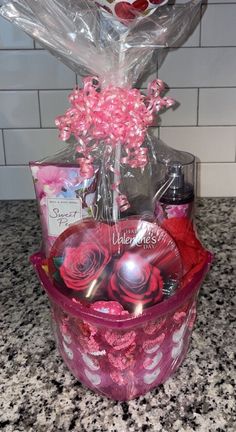 a pink basket filled with lots of different items on top of a granite countertop