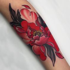 a red flower tattoo on the arm