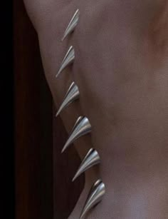 the back of a woman's body with metal spikes on it